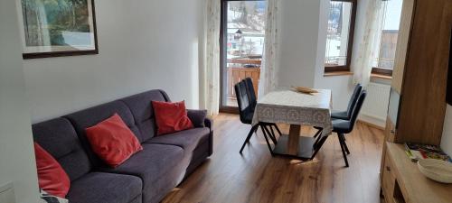 a living room with a couch and a table with chairs at Ottohof - Morgenrot in Brennero