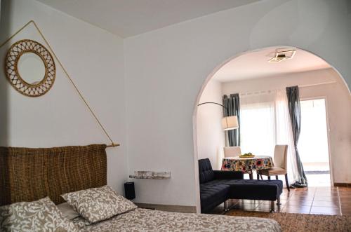 a living room with a bed and a mirror at HOTELITO RURAL GA7COLORES only adult in Montaña Blanca