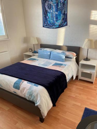 a bedroom with a large bed with blue pillows at Streatham Common Bed & Breakfast in London