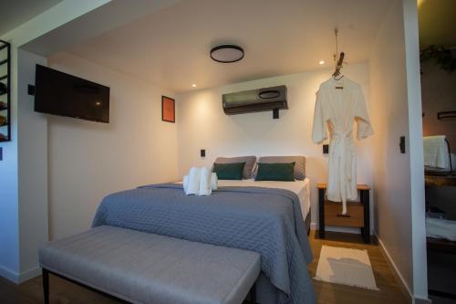 ein Schlafzimmer mit 2 Betten und einem an der Wand hängenden Bademantel in der Unterkunft Casa Container - Haupt Village in Farroupilha
