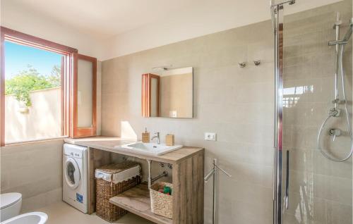 a bathroom with a sink and a washing machine at Lovely Home In Comiso With House A Panoramic View in Comiso