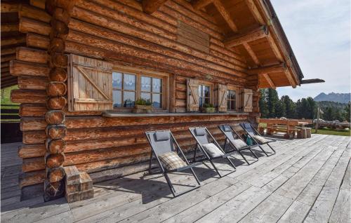 a group of chairs sitting on the deck of a log cabin at Chalet Luisa in Predazzo