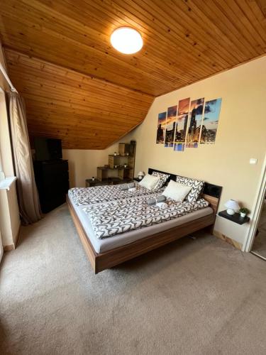 ein großes Bett in einem Zimmer mit Holzdecke in der Unterkunft Gebino apartman in Zamárdi