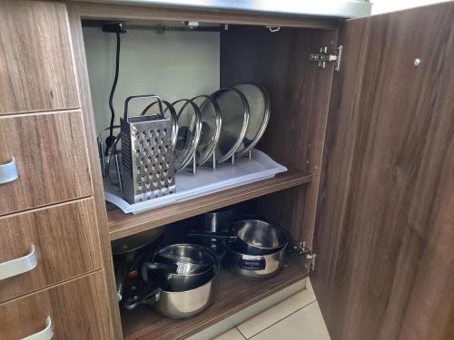 a kitchen cabinet with pots and pans in it at Penzion Na Pohoři in Olešnice