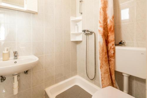 a bathroom with a shower and a toilet and a sink at Apartment and Rooms Dalmatiko in Vodice