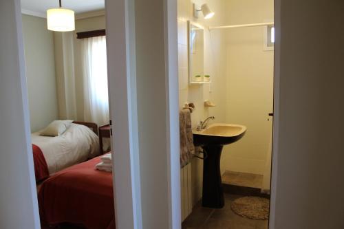 1 dormitorio con 1 cama y baño con lavabo. en Palacio Centro en San Carlos de Bariloche