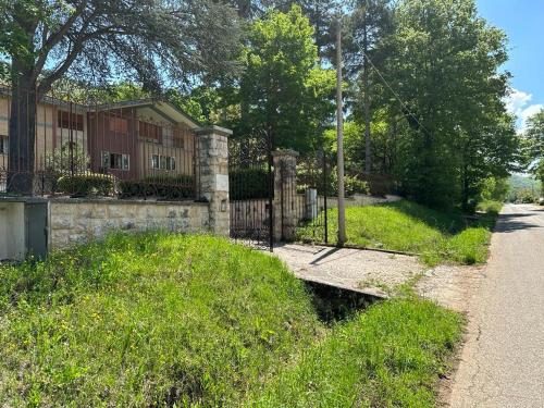 una casa con una valla y un campo de hierba en VILLA OLGA, en Cese