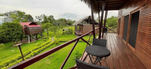a balcony with a table and chairs on a house at Waylla Eco Refugio in Tarapoto