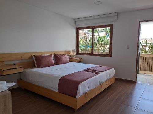 a bedroom with a large bed and a window at Hotel Gran Plaza San Agustin in San Agustín