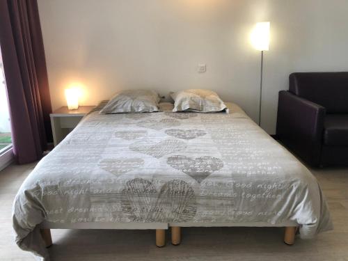 een bed met twee kussens in een slaapkamer bij Appart LOURDES 100 m GARE - 4 Places avec Balcon 10mn Sanctuaire in Lourdes