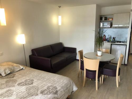 un salon avec un lit, une table et un canapé dans l'établissement Appart LOURDES 100 m GARE - 4 Places avec Balcon 10mn Sanctuaire, à Lourdes