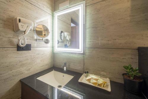 a bathroom with a sink and a mirror at Royal Ace Boutique Hotel - Manyata Techpark in Bengaluru