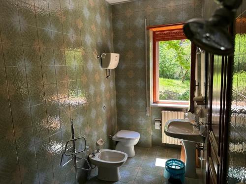a bathroom with two sinks and a toilet and a window at VILLA OLGA in Cese