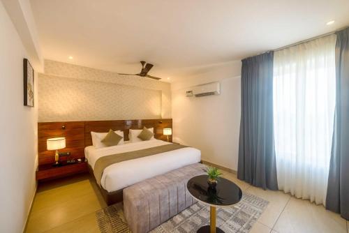 a hotel room with a bed and a table at Royal Ace Boutique Hotel - Manyata Techpark in Bengaluru