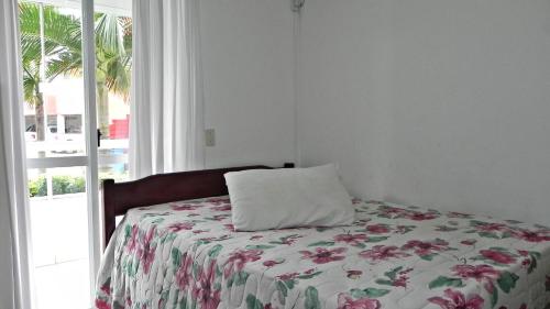 1 dormitorio con cama con almohada en 1031 - Apartamento para locação em Bombinhas - Residencial Solar das Bromélias Apto 157, en Bombinhas
