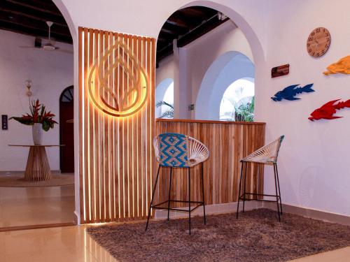 卡塔赫納的住宿－Hotel Casa Agustina，一间设有两把椅子和木墙的房间