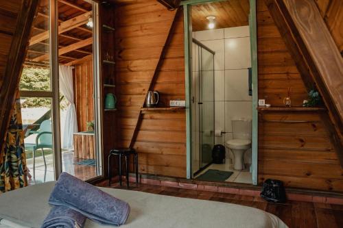 a bedroom with a toilet and a glass shower at Recanto do Vale in Pomerode