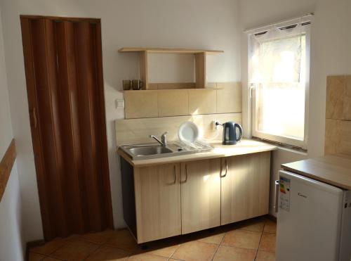 Elle comprend une petite cuisine avec un évier et une fenêtre. dans l'établissement Ośrodek Wypoczynkowy A26 - Mazury, à Ełk