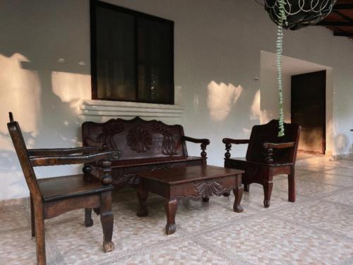 a room with two chairs and a table and a bench at El Bosque Hotel in Copán Ruinas