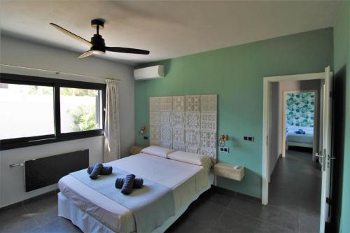 um quarto com uma cama e uma ventoinha de tecto em Casa moderna a 300 metros de la playa. em Sant Josep de sa Talaia