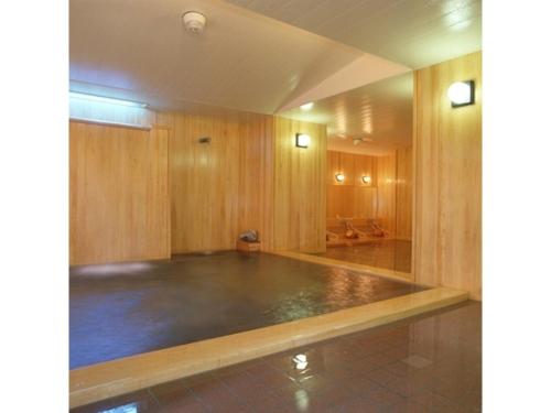 una grande stanza vuota con una palestra con pareti in legno di Ikaho Onsen Sanyo Hotel - Vacation STAY 26406v a Shibukawa