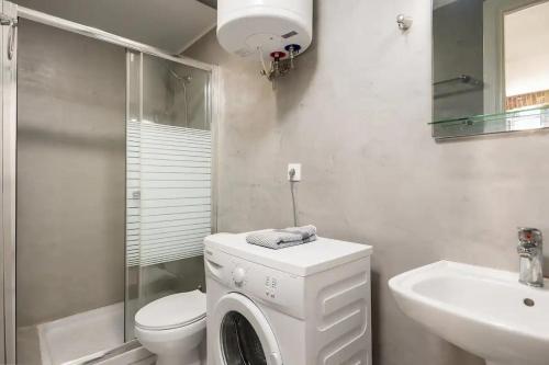 a bathroom with a washing machine and a sink at Q Apartments in Corfu Town in Corfu