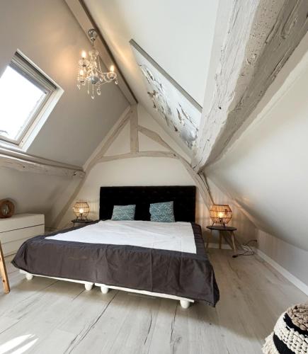 une chambre avec un lit dans un grenier dans l'établissement Le grenier des inities, à Manneville-la-Raoult