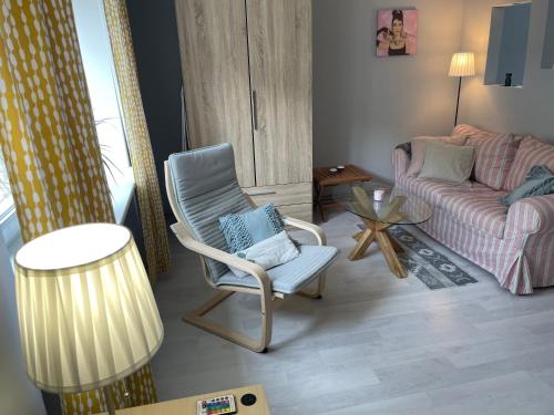 - un salon avec une chaise et un canapé dans l'établissement Linden Blossom, à Liepāja