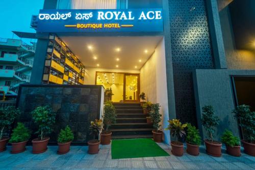 a lobby of a hotel with potted plants and stairs at Royal Ace Boutique Hotel - Manyata Techpark in Bengaluru