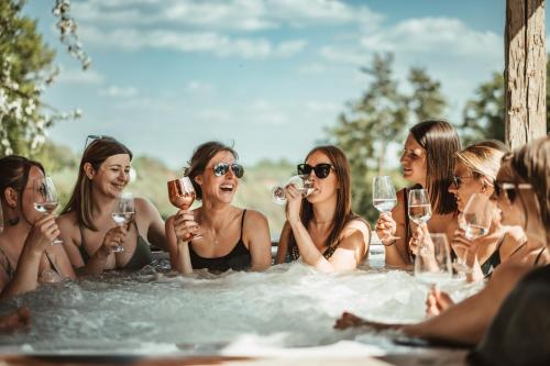 a group of women in a bathtub drinking wine at Wohlfühloase am Trausdorfberg mit Sauna, Whirlpool und Panorama in Sankt Marein bei Graz
