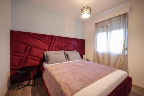 a bedroom with a large bed with a red headboard at Boutique Apartments Ad Astra in Bibinje