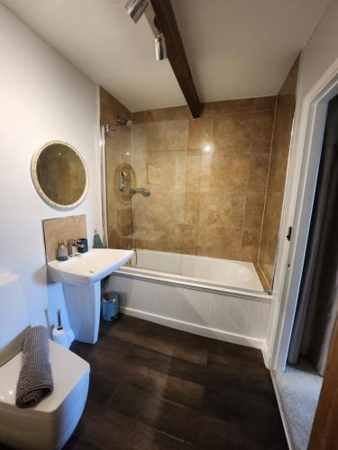 uma casa de banho com um chuveiro, um lavatório e uma banheira em East Cote Cottage em Settle