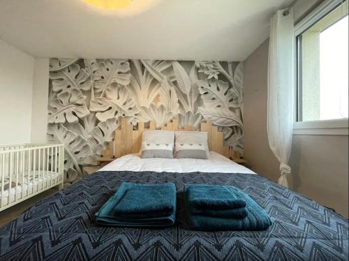 Un dormitorio con una cama con toallas azules. en Gîte La Clé de Saint-Jean, en Ergny