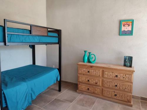 een slaapkamer met een stapelbed en een houten dressoir bij Cabaña en Mesa de las Tablas, de fácil acceso y con excelentes vistas in Mesa de las Tablas