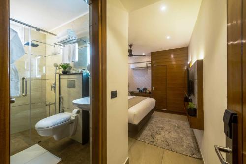 La salle de bains est pourvue d'un lavabo, de toilettes et d'une douche. dans l'établissement Royal Ace Boutique Hotel - Manyata Techpark, à Bangalore