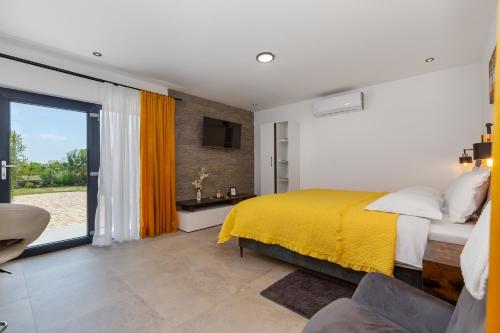 1 dormitorio con cama amarilla y TV en Studio Apartment Carpe Diem, en Drinovci