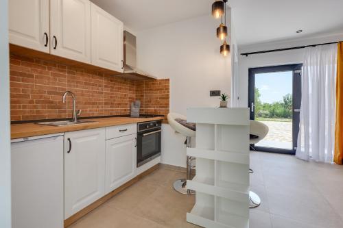 eine Küche mit weißen Schränken und einem Waschbecken in der Unterkunft Studio Apartment Carpe Diem in Drinovci