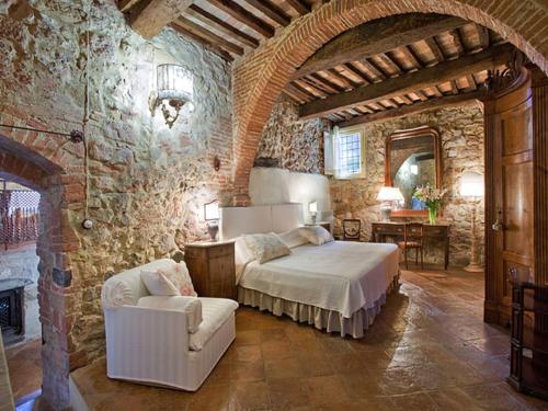 um quarto com uma cama e uma parede de pedra em Valdorcia, tipico toscano em Montefollonico