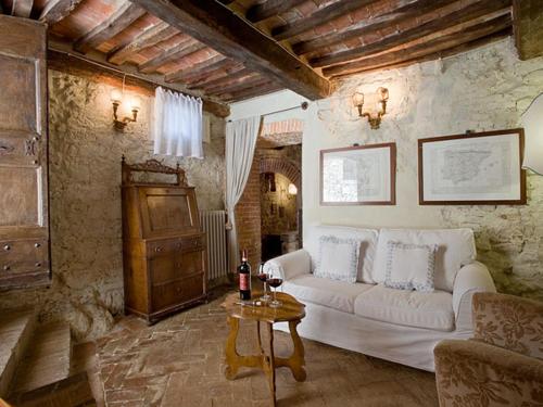 uma sala de estar com um sofá branco e uma mesa em Valdorcia, tipico toscano em Montefollonico