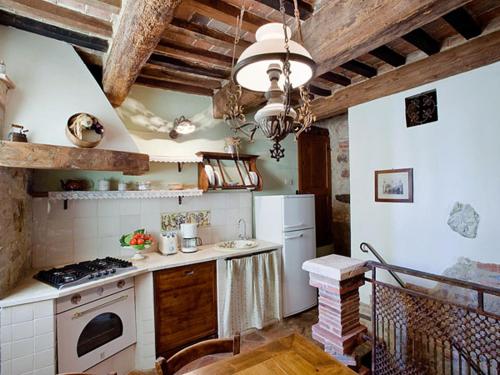 uma cozinha com um fogão e um fogão forno superior em Valdorcia, tipico toscano em Montefollonico