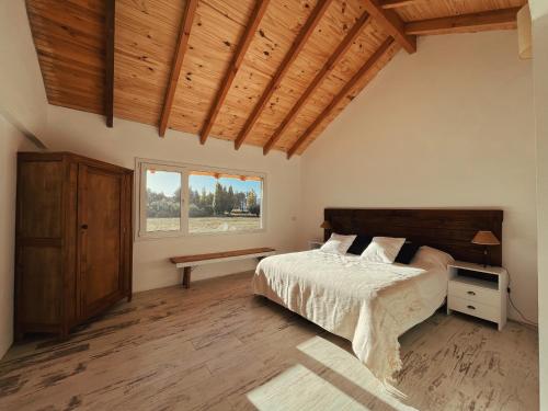 1 dormitorio con cama y techo de madera en Casa de Campo La Chacra en San Carlos de Bariloche