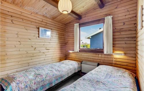 two beds in a log cabin with a window at 2 Bedroom Awesome Home In Faaborg in Faaborg