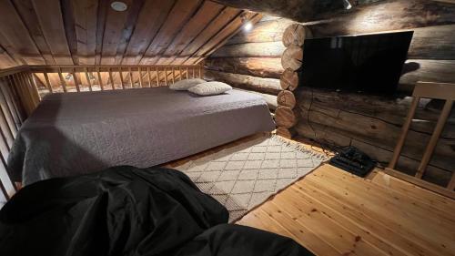 a bedroom with a bed and a flat screen tv at Kelokallas 2 Ruka in Ruka