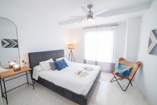 een slaapkamer met een bed, een stoel en een spiegel bij Balcón de Marina del Este in La Herradura