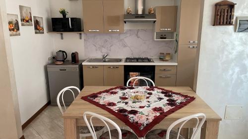 a kitchen with a wooden table with a table cloth on it at Rose e Frutta - Yellow Daisy in Ronchi dei Legionari