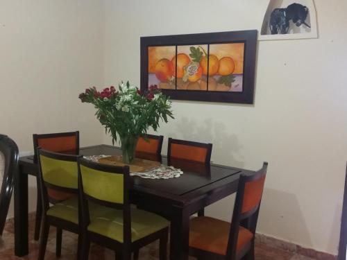 una mesa de comedor con sillas y un jarrón de flores en Victoria brand 2, en Bogotá