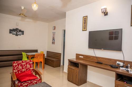 a living room with a flat screen tv on a wall at Ronnie's Studio Apartment in Arpora