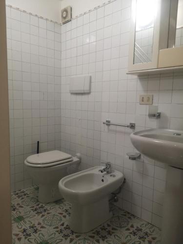 a white bathroom with a toilet and a sink at Al Limone in Lipari