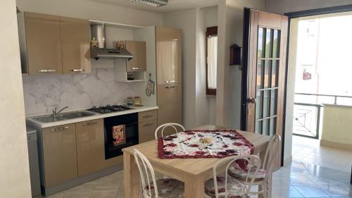 a kitchen with a table and a sink and a stove at Rose e Frutta ristrutturato con parcheggio in Ronchi dei Legionari