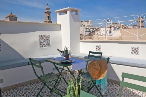 a patio with a table and chairs on a balcony at NEREA - Apulian Suite and Rooms in Monopoli